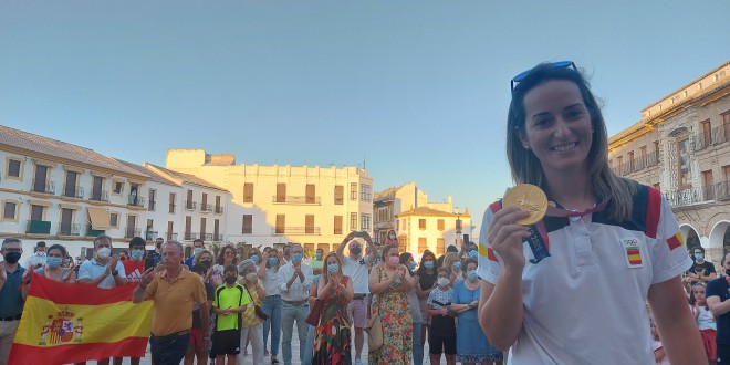 La campeona olímpica, Fátima Gálvez, posa con la medalla de oro en la Plaza de la Constitución rodeada de numerosos vecinos de Baena. Foto: TV Baena.